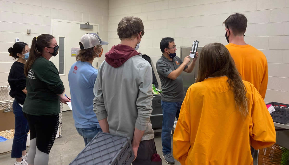 Instructor demonstrating a piece of equipment with students watching